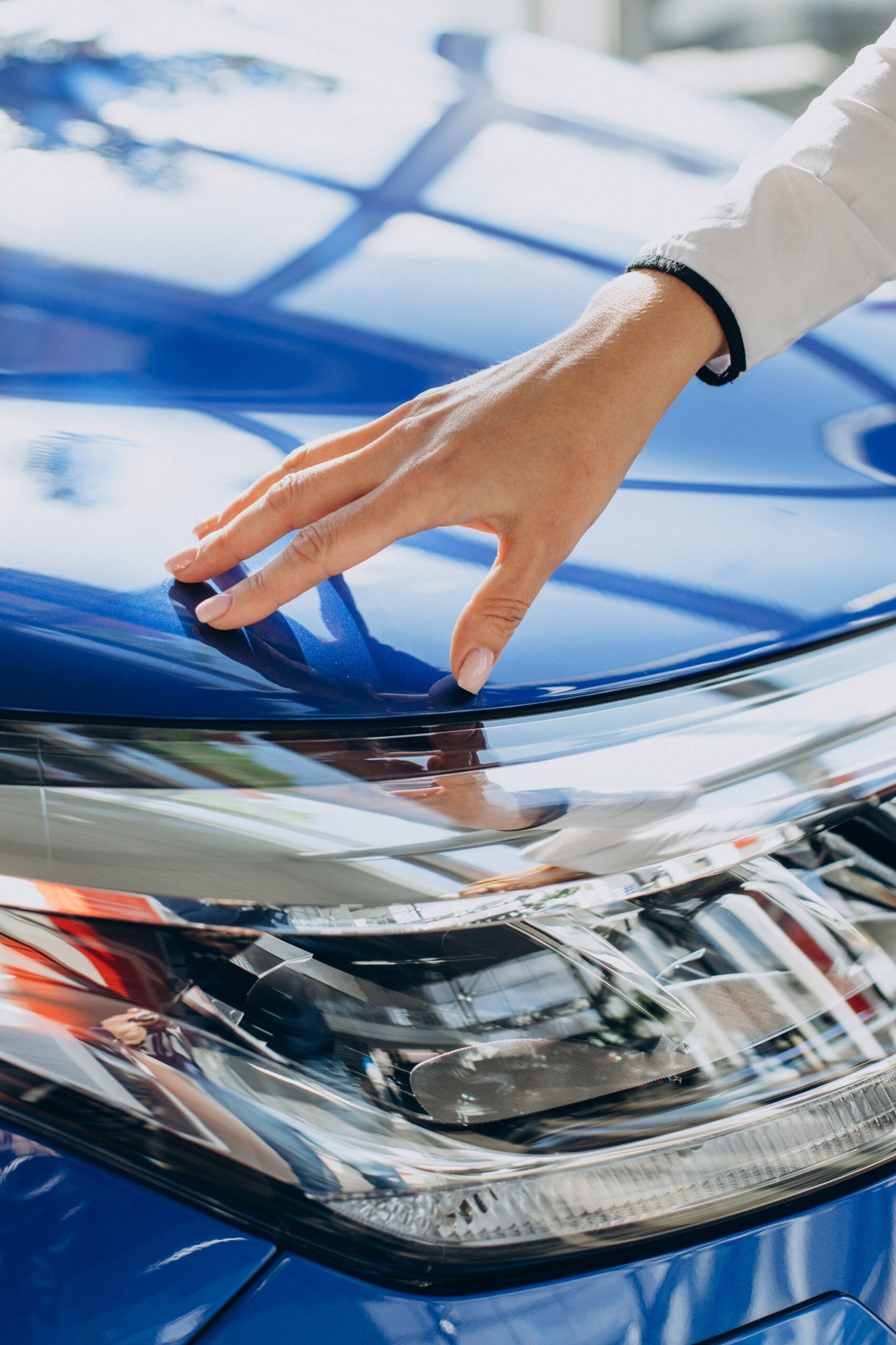 female-hands-touching-new-blue-car-close-up-scaled.jpg